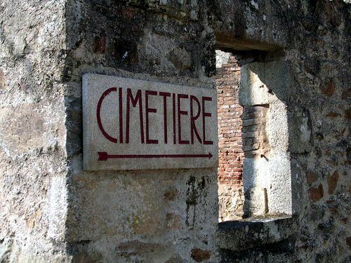 Photo of a sign directing visitors to the cemetery in Oradour-sur-Glane.